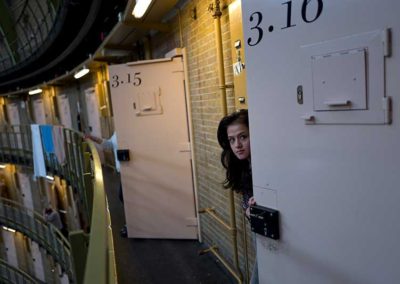 19-year-old Afghan refugee Shazia Lutfi peeks through the door of her room at the former prison of De Koepel in Haarlem, Netherlands, May 2016.